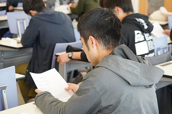 学生たちは説明に耳を傾け、資料に目を通していました。